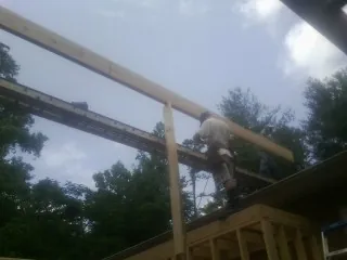 Carpenter setting a ridge beam over a new addition frame — Ice Dam Removal by Roofing Brothers in West Harrison