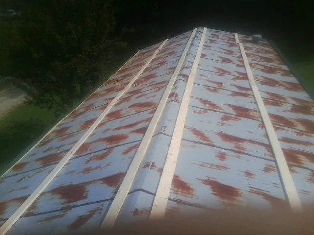 Rusted metal roof panels with new wood purlins before replacement — Storm Damage Roof Repair in West Harrison by Roofing Brothers